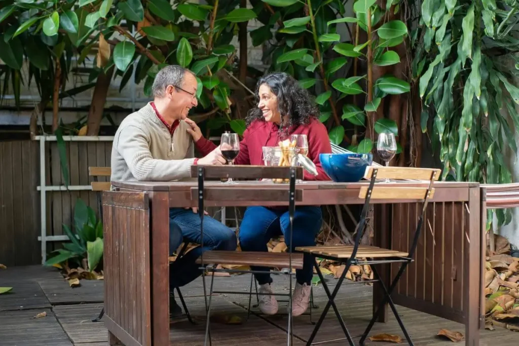 Casal conversando de forma conectada e presente à mesa com luz natural